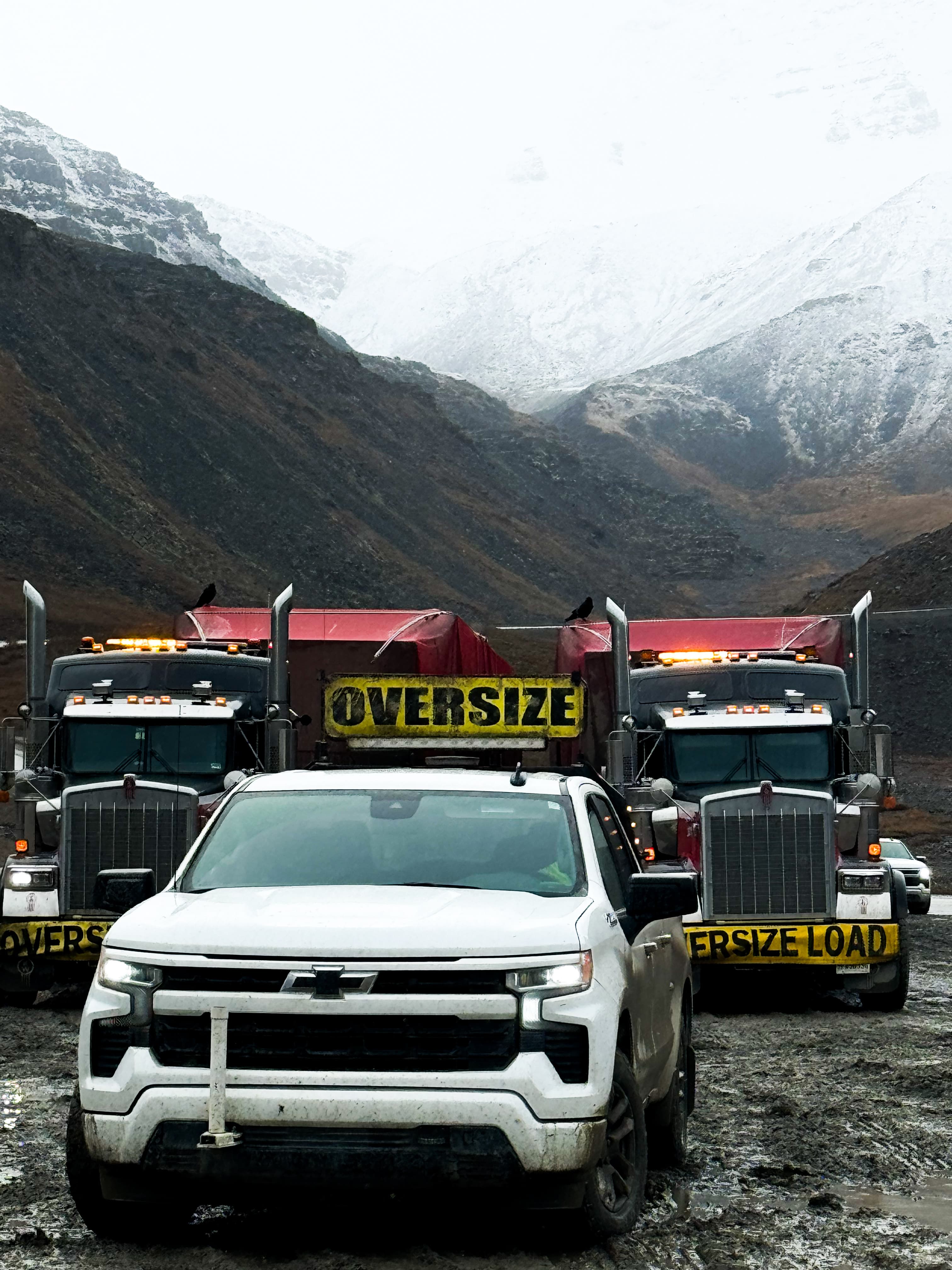 Rig Runner pilot car in front of heavy haul trucks in Alaska’s mountains